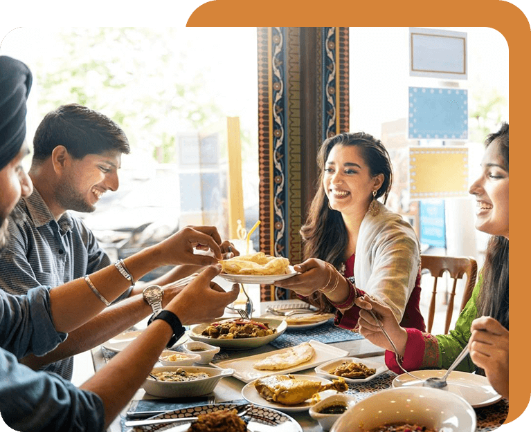 A group of people sitting at a table eating food.